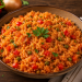 Aromatischer Djuvec-Reis mit Paprika, Erbsen und Tomaten, locker gegart und mit frischer Petersilie verfeinert, serviert in einer rustikalen Schale auf einem Holztisch.