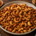 Hausgemachte Würznüsse aus gerösteten Cashewkernen und Mandeln mit einer würzigen Gewürzmischung, knusprig gebacken und in einer rustikalen Schale serviert.