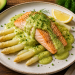 Gebratenes Lachsfilet mit weißem Spargel auf cremiger Avocado-Hollandaise, garniert mit frischem Dill und Schnittlauch, serviert auf einem rustikalen Teller mit Zitronenspalte.