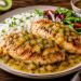 Saftige Hähnchenbrustfilets mit fruchtiger Kiwisauce, serviert mit lockerem Reis und frischem Blattsalat auf einem rustikalen Teller.
