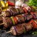 Gegrillte spanische Rindfleischspieße mit saftigen Rindfleischwürfeln, roter und grüner Paprika sowie roten Zwiebeln auf einer dunklen Servierplatte. Umgeben von mediterranen Zutaten wie Oliven, Knoblauch, Kräutern und Olivenöl. Fotorealistische Darstellung eines spanischen Grillgerichts im rustikalen Stil.