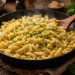Frisch zubereitete, goldgelbe Spätzle in einer schwarzen Pfanne, mit geschmolzener Butter und fein gehackter Petersilie verfeinert, dampfend serviert auf einem rustikalen Holztisch in warmer, natürlicher Beleuchtung.